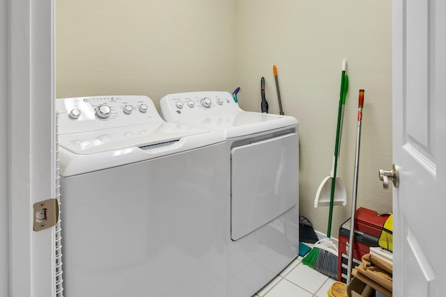 laundry area with separate washer and dryer and light tile patterned flooring