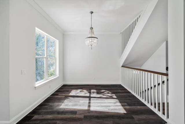 empty room featuring ornamental molding, a notable chandelier, and dark hardwood / wood-style flooring