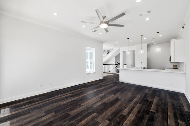 unfurnished living room with dark hardwood / wood-style flooring, sink, ornamental molding, and ceiling fan