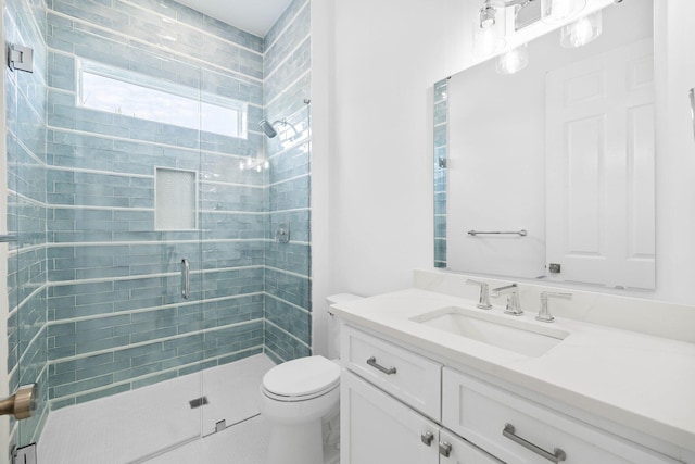 bathroom with an enclosed shower, vanity, and toilet