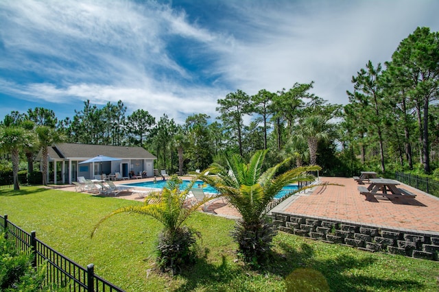 view of swimming pool featuring a patio and a yard