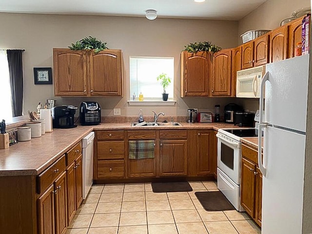 kitchen featuring sink, light tile patterned floors, and white appliances