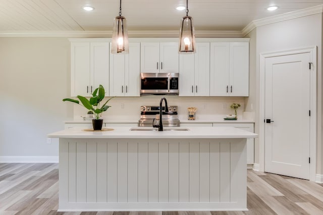 kitchen with a kitchen island with sink, pendant lighting, and white cabinets