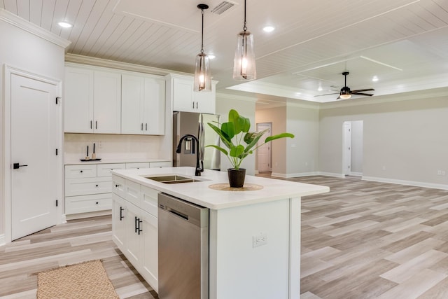 kitchen featuring decorative light fixtures, an island with sink, white cabinetry, sink, and stainless steel appliances