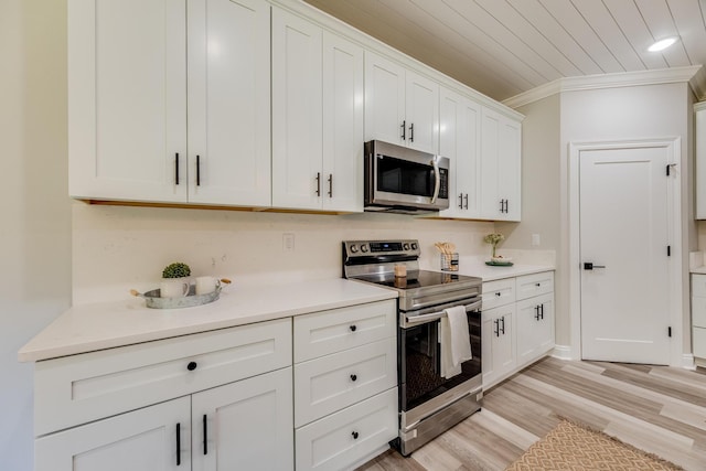 kitchen featuring wood ceiling, white cabinetry, stainless steel appliances, ornamental molding, and light hardwood / wood-style floors