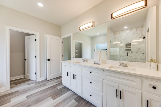 bathroom featuring vanity, hardwood / wood-style flooring, and tiled shower