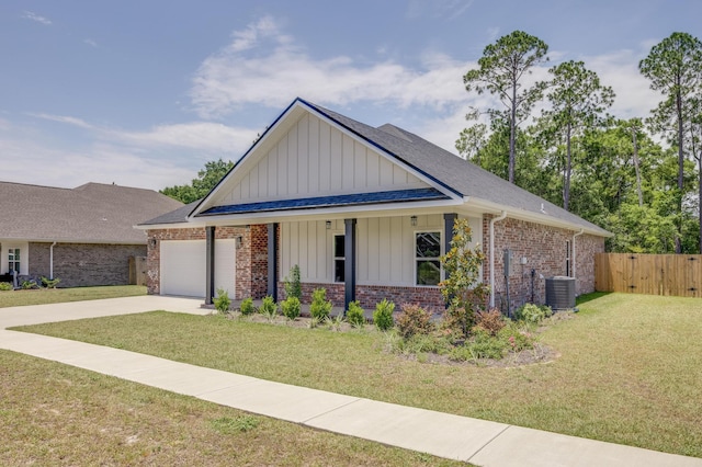 view of front of property featuring a garage, a front lawn, and central air condition unit