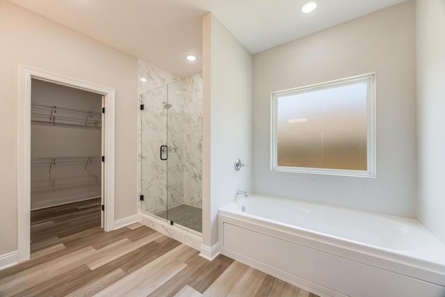 bathroom with hardwood / wood-style flooring and separate shower and tub