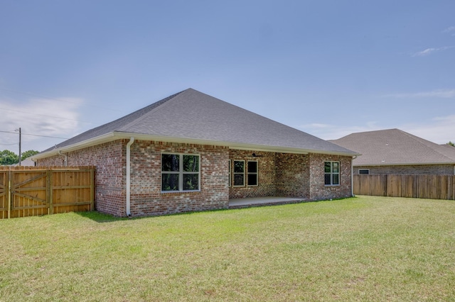 back of house with a patio and a lawn