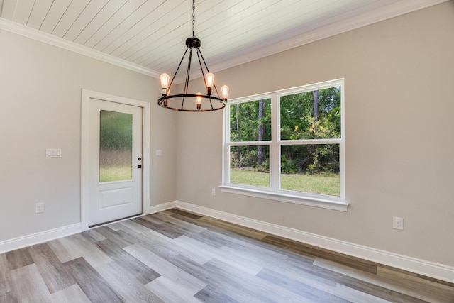 interior space with an inviting chandelier, ornamental molding, light hardwood / wood-style floors, and a healthy amount of sunlight