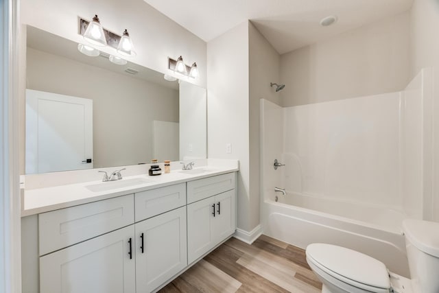 full bathroom with wood-type flooring, toilet, shower / washtub combination, and vanity