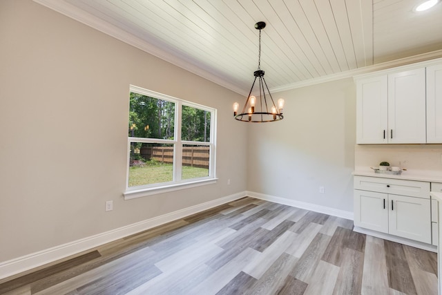 unfurnished dining area featuring crown molding, wood ceiling, a chandelier, and light wood-type flooring