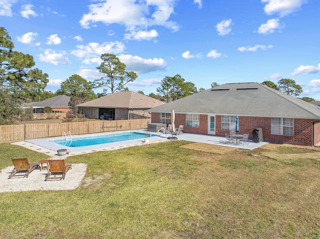 view of pool with a patio and a lawn