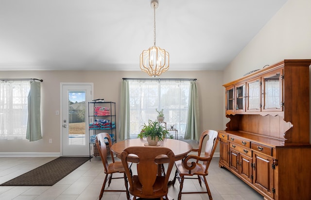 dining space with an inviting chandelier, light tile patterned floors, and vaulted ceiling