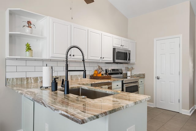 kitchen with sink, appliances with stainless steel finishes, light stone counters, white cabinets, and kitchen peninsula