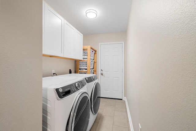 laundry area featuring cabinets, light tile patterned flooring, and separate washer and dryer