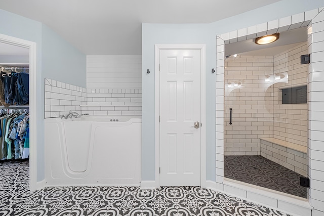 bathroom with an enclosed shower and tile patterned floors