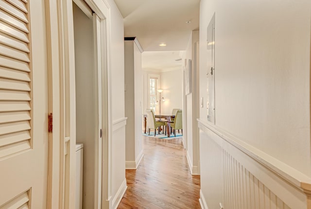 corridor with crown molding and light hardwood / wood-style flooring