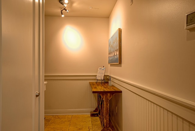 hallway featuring light tile patterned floors and rail lighting