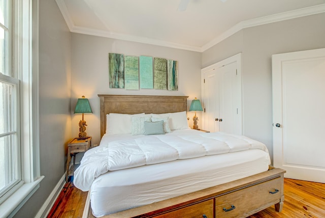 bedroom with crown molding, hardwood / wood-style floors, and ceiling fan