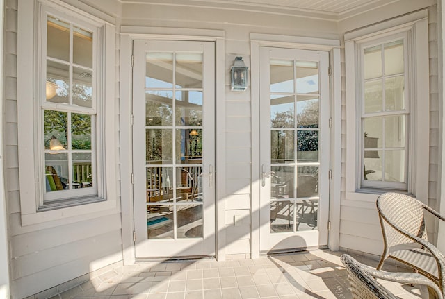 doorway to outside with tile patterned floors and wooden walls