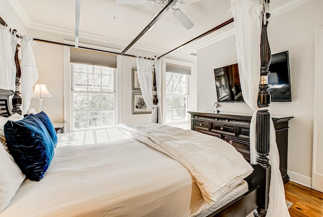 bedroom featuring hardwood / wood-style flooring, crown molding, and ceiling fan