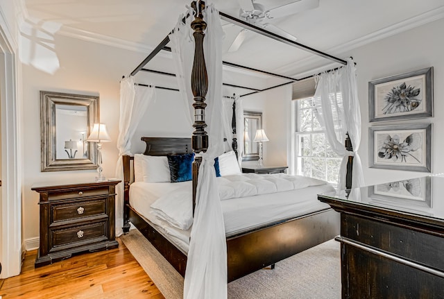 bedroom with ceiling fan, ornamental molding, and light hardwood / wood-style floors