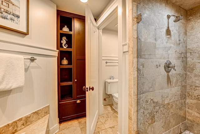 bathroom featuring toilet and a tile shower