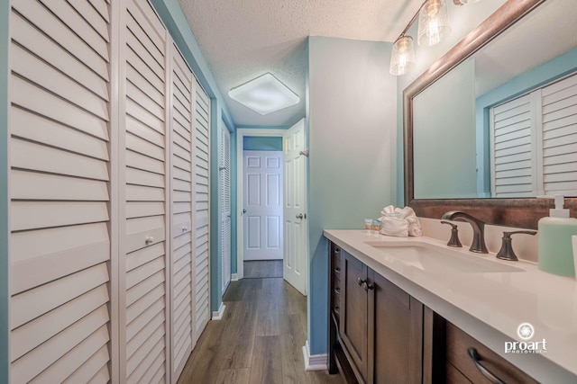 bathroom with vanity, hardwood / wood-style floors, and a textured ceiling