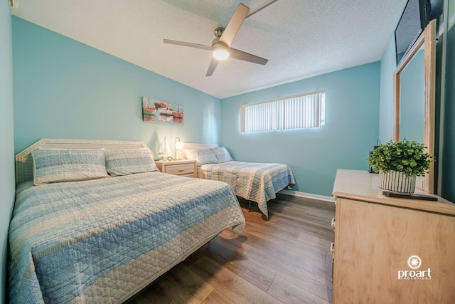 bedroom featuring hardwood / wood-style floors, a textured ceiling, and ceiling fan