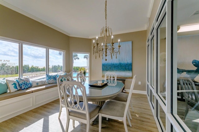 dining area with a notable chandelier, light hardwood / wood-style flooring, and ornamental molding