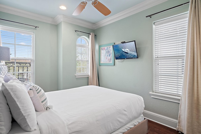 bedroom featuring dark wood-type flooring, ornamental molding, and ceiling fan