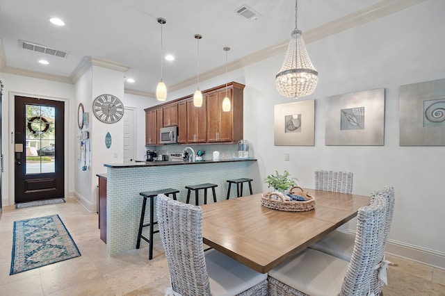 dining space featuring crown molding and a chandelier