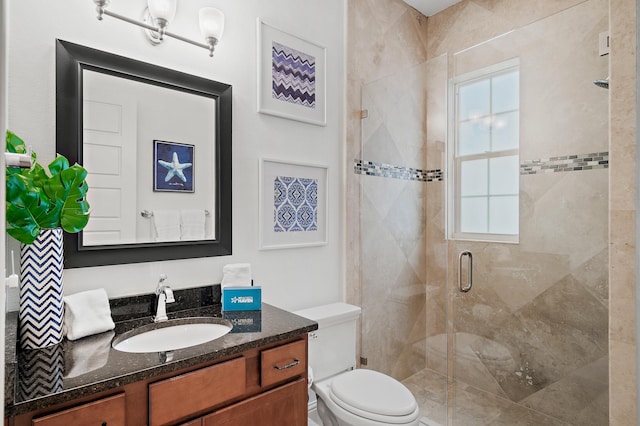 bathroom with an enclosed shower, vanity, and toilet