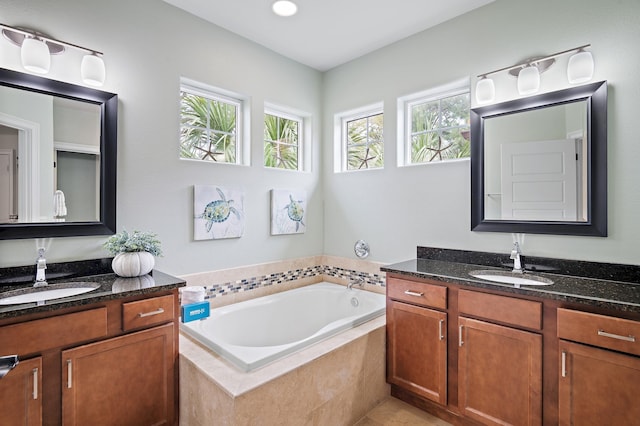 bathroom with vanity and tiled tub