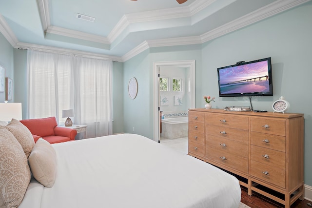 bedroom with ensuite bathroom, crown molding, and a tray ceiling