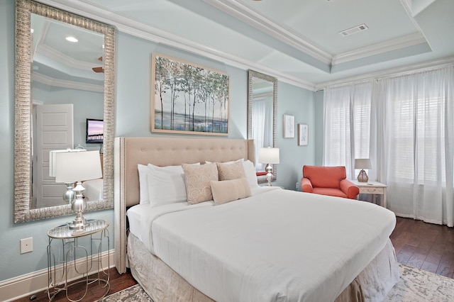 bedroom with crown molding, dark wood-type flooring, and a raised ceiling