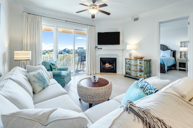 living room featuring crown molding, ceiling fan, and light hardwood / wood-style flooring