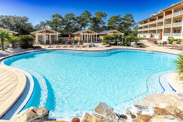 view of pool featuring an outdoor structure and a patio