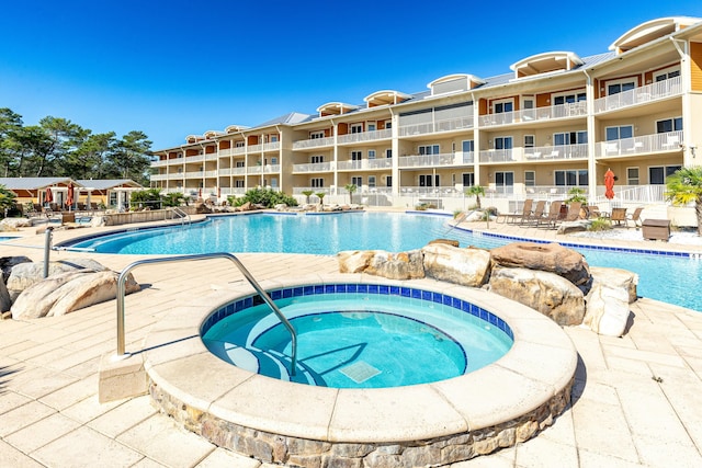 view of pool with a patio area and a community hot tub