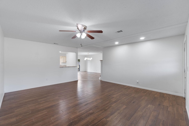 empty room with dark hardwood / wood-style floors, ceiling fan with notable chandelier, and a textured ceiling