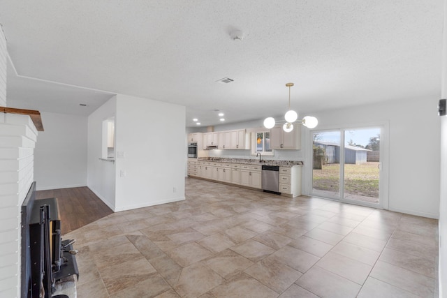 kitchen with decorative light fixtures, a chandelier, stainless steel appliances, a textured ceiling, and cream cabinetry