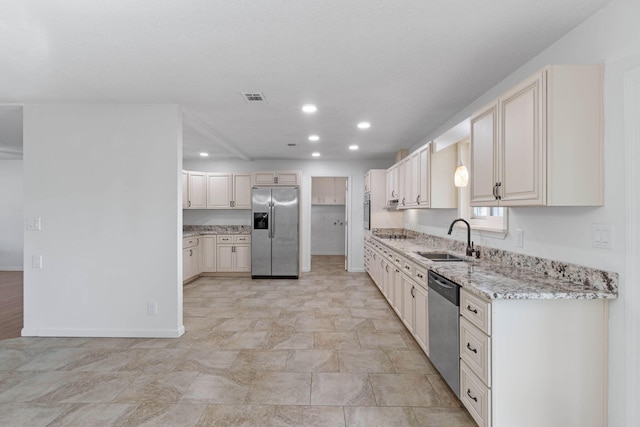 kitchen featuring sink, stainless steel appliances, and light stone countertops