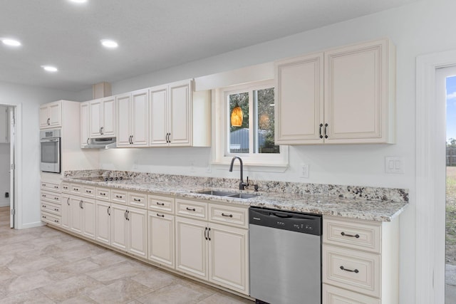 kitchen with stainless steel appliances, sink, and light stone counters