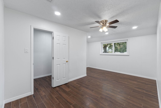 spare room with ceiling fan, dark wood-type flooring, and a textured ceiling