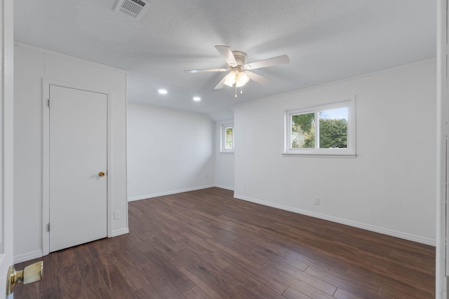 unfurnished room with a textured ceiling, dark wood-type flooring, and ceiling fan