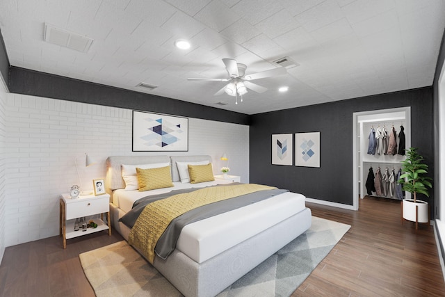 bedroom with hardwood / wood-style flooring, ceiling fan, a spacious closet, and a closet