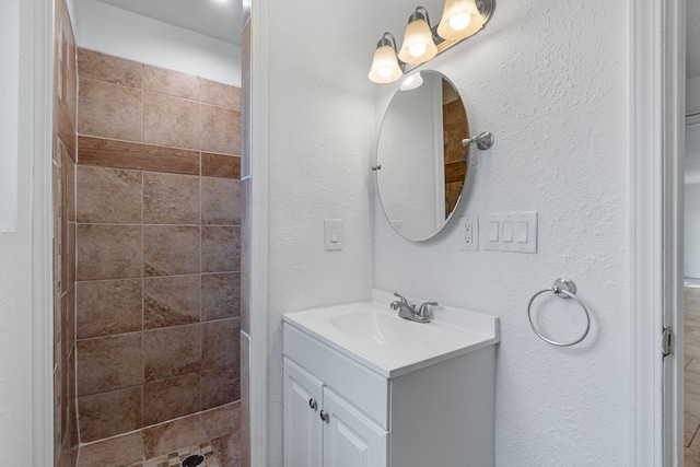 bathroom with vanity and a tile shower