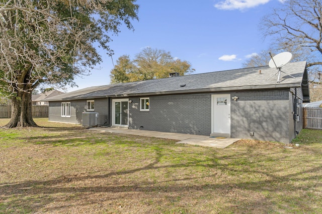 rear view of house featuring cooling unit, a lawn, and a patio area