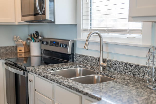 3986 W County Highway 30a Unit 231, Santa Rosa Beach, FL 32459 - kitchen with appliances with stainless steel finishes, dark stone countertops, a sink, and white cabinets